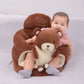 Smiling baby sitting in a brown bear plush floor seat with the padded ring around them
