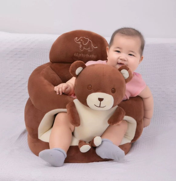 Smiling baby sitting in a brown bear plush floor seat with the padded ring around them