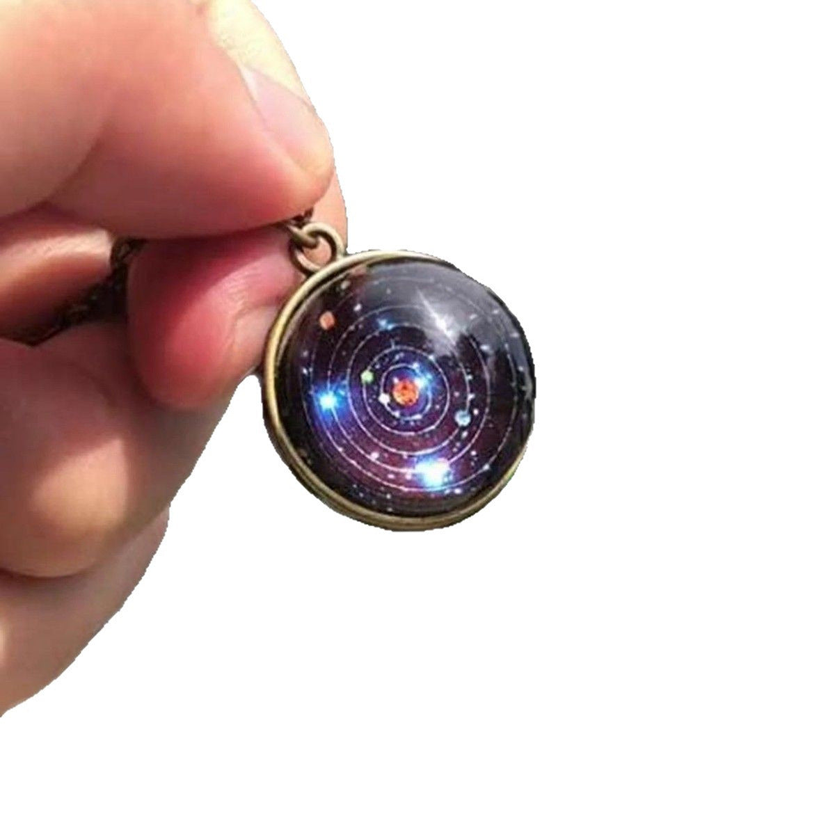 Glass solar system ball pendant in a bronze tone ring held against a plain white background