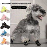 Gray schnauzer standing in black soft sole dog shoes beside a vertical row of the five colour options