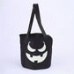 Colored canvas trick or treat bucket with a printed pumpkin face and carry handles