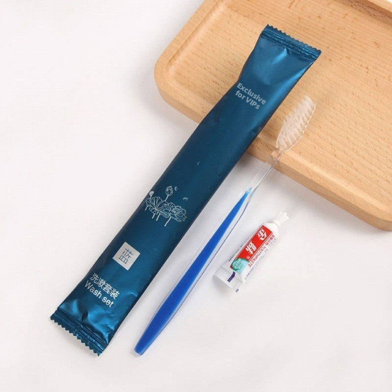 Disposable travel toothbrush and toothpaste set shown with a sealed film pouch on a plain ground