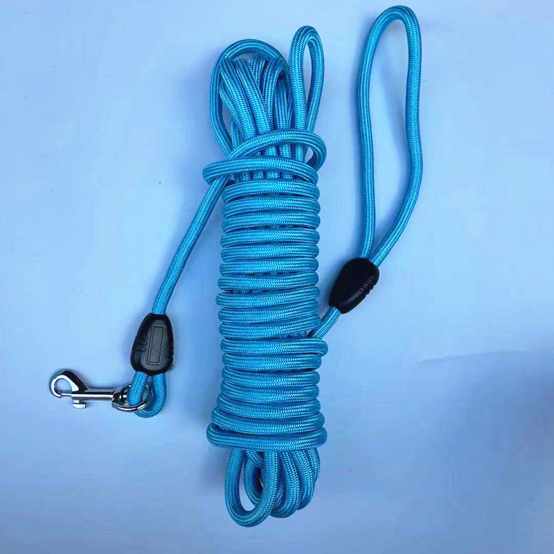 Round braided nylon pet training long line coiled beside its metal trigger snap clip