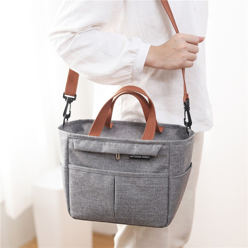 Top zip closure of the insulated lunch bag holding a stacked lunch container upright