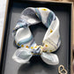 White and blue equestrian printed square scarf with a satin sheen and hemmed edges, shown displayed