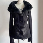 Black ribbed knit cardigan with a wide plush collar on a mannequin, with a plaid top and pearl necklace
