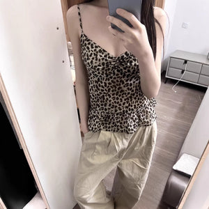 Retro leopard cami with ruffle hem worn over beige trousers in a mirror view