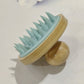 Blue bamboo and silicone scalp massage brush with a domed wooden knob grip