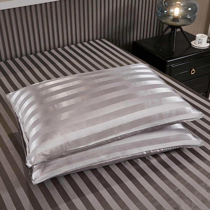 Navy blue stripe satin pillowcase resting against a headboard