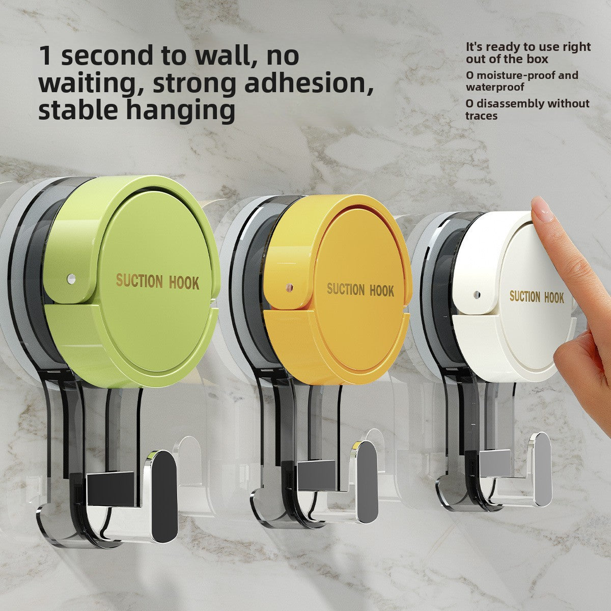 Green, yellow and white suction cup hooks on a marble wall with a finger pressing the white cap