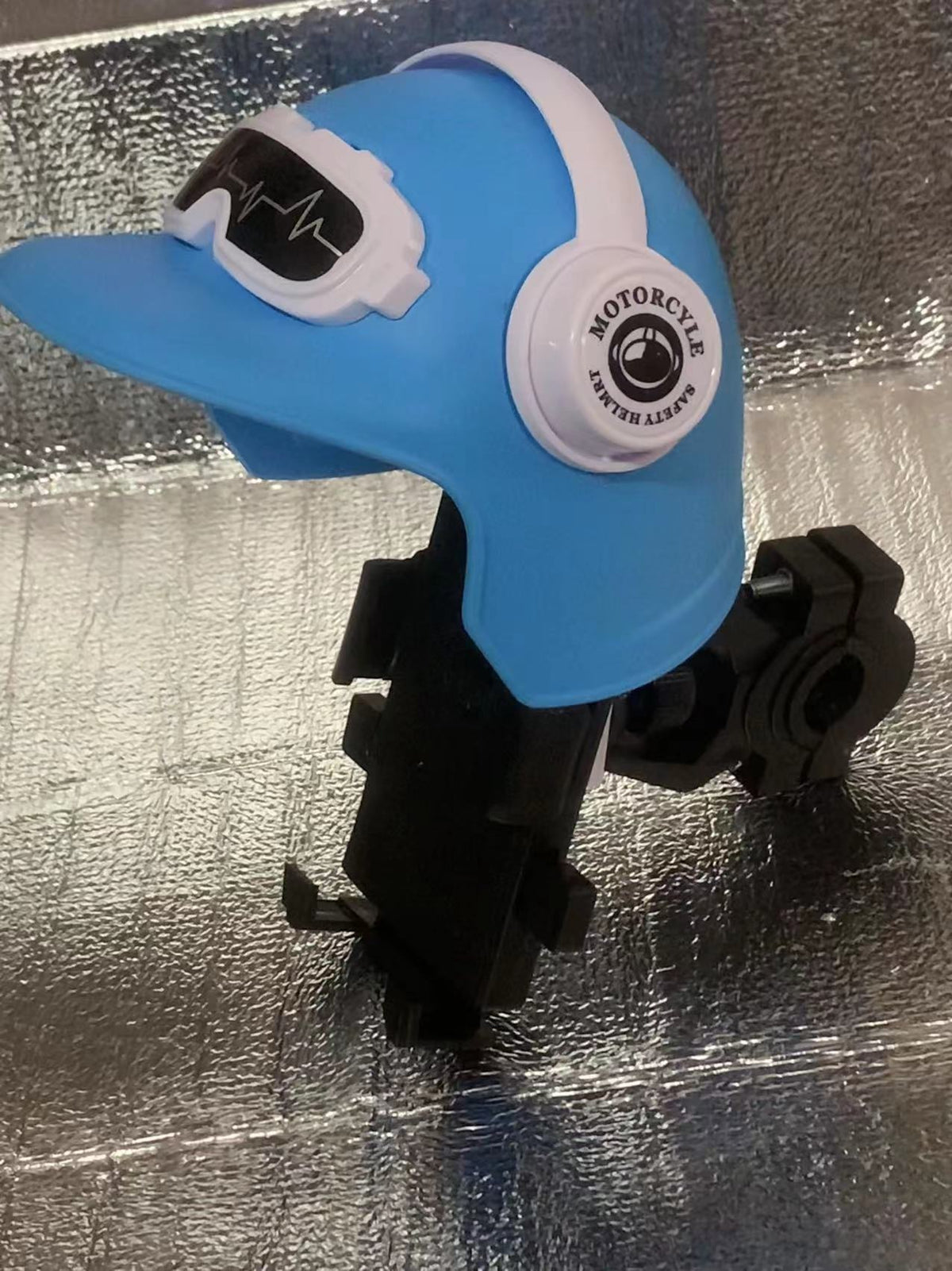 Handlebar with helmet, blue option: blue small helmet visor over a phone holder on a handlebar clamp