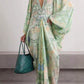 Light green printed V-neck dress with a draped front fold and wide sleeves, model with hand on hip