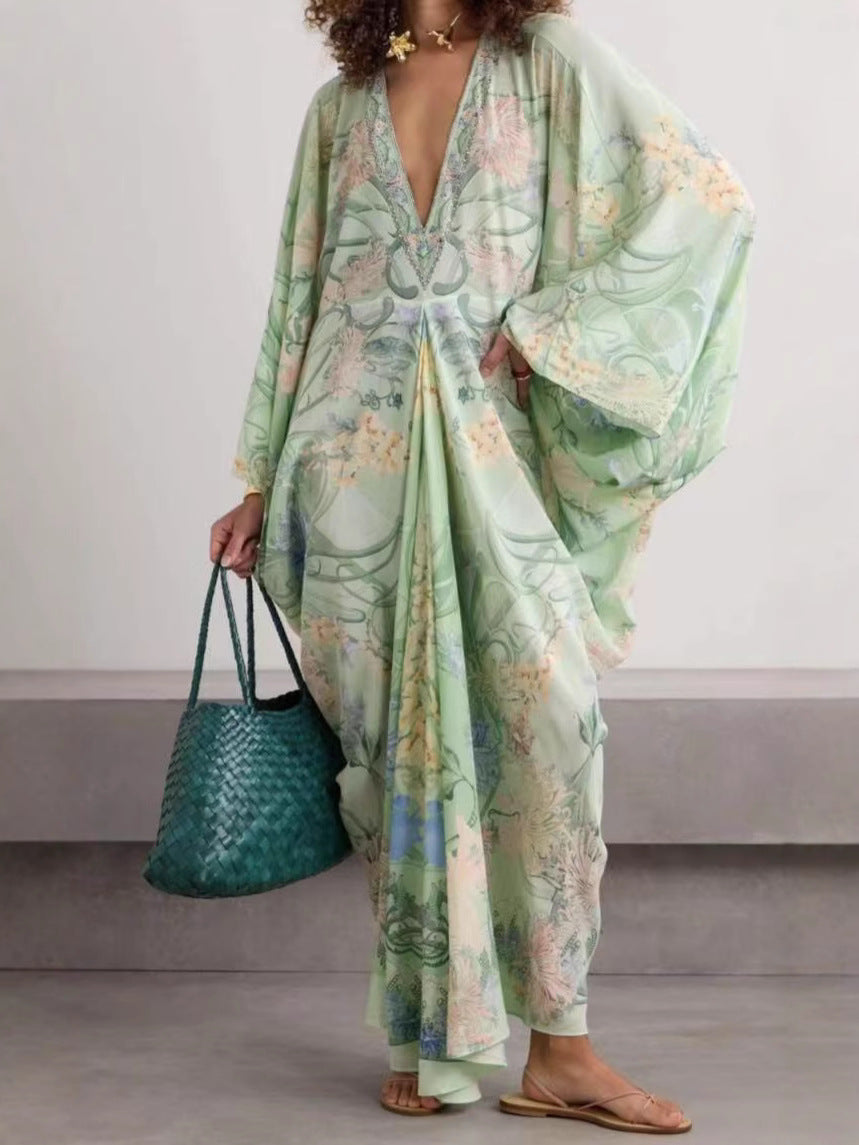 Light green printed V-neck dress with a draped front fold and wide sleeves, model with hand on hip