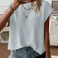 Solid color cap sleeve knit top with a round neck shown on a model against a plain room