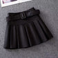 Black with Belt variant, size 2XL: black pleated mini skirt with a self-fabric belt laid flat on gray carpet