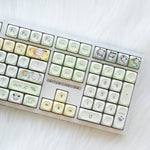 Milk-green Xiu dog keycaps on the number pad and arrow keys of the white 108-key keyboard