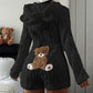 Black plush hooded romper with bear ears and a teddy bear back patch, shown on the Black size L option