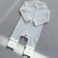 Natural White zip front baby romper laid flat on a gray floor, image of the 73 cm, 6 to 12 months size option