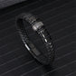 Black braided leather bracelet coiled to show the woven strands and steel clasp