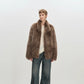 Taupe faux fur coat laid against a pale ground, long pile and open front visible