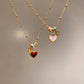 Close view of the glossy red enamel heart pendant on a gold tone chain