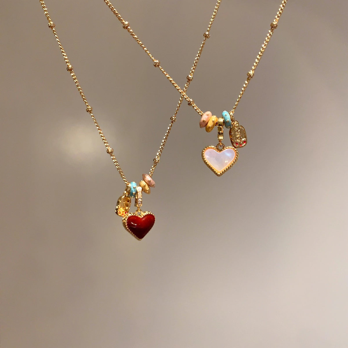 Close view of the glossy red enamel heart pendant on a gold tone chain