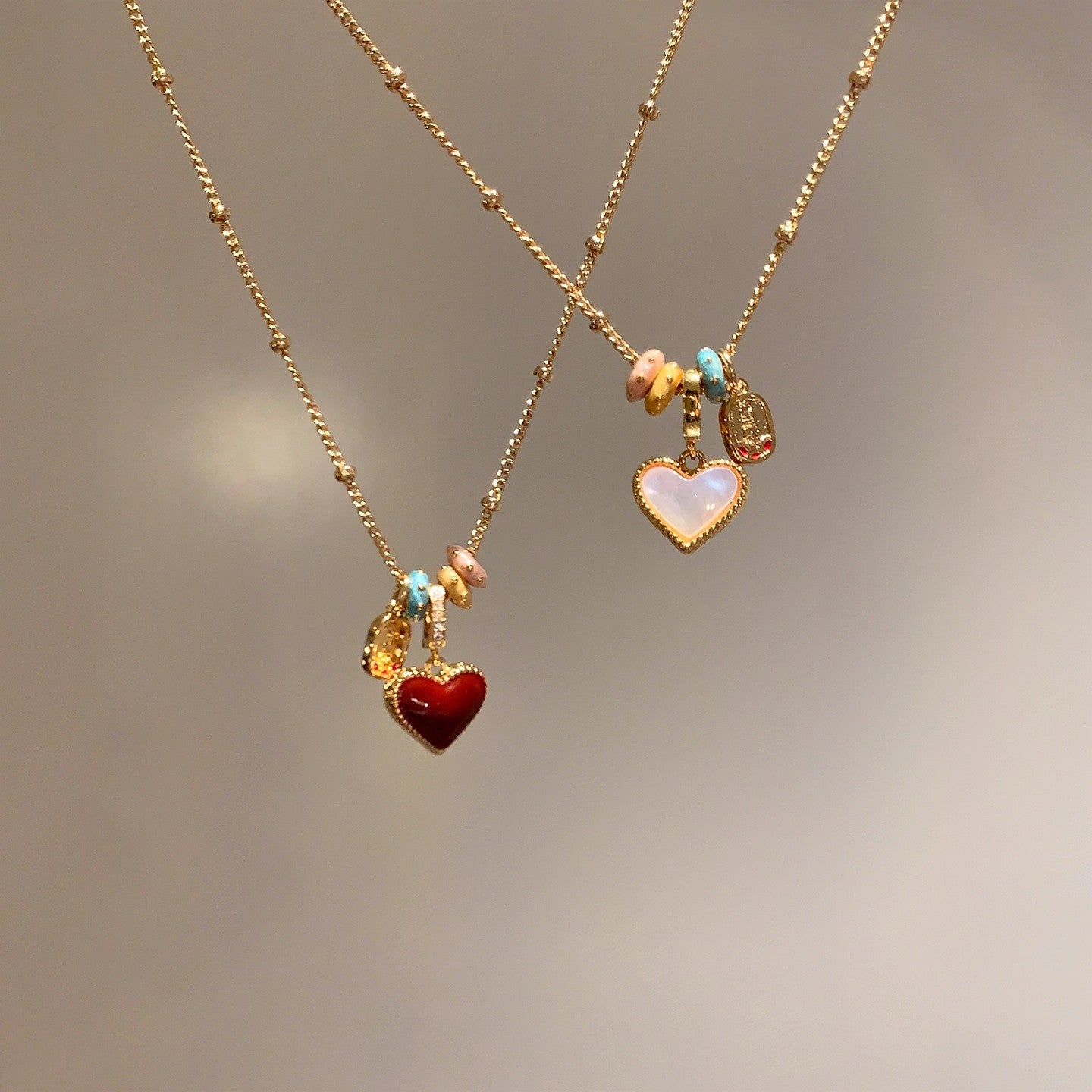 Close view of the glossy red enamel heart pendant on a gold tone chain