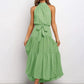 Green polka dot halter neck sleeveless tiered swing maxi dress worn by a model