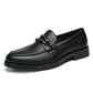 Single black slip-on loafer on white, braided saddle strap, burgundy lining and lugged rubber outsole