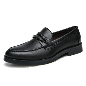 Single black slip-on loafer on white, braided saddle strap, burgundy lining and lugged rubber outsole