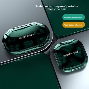 Green portable pill organizer oval and square cases with clear lids on dark surface