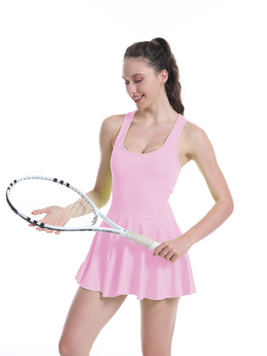 Pink athletic tennis dress front view with scoop neck, fitted bodice and flared skater skirt, racket in hand