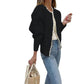 Side view of the black faux pearl trimmed knit cardigan worn open over jeans
