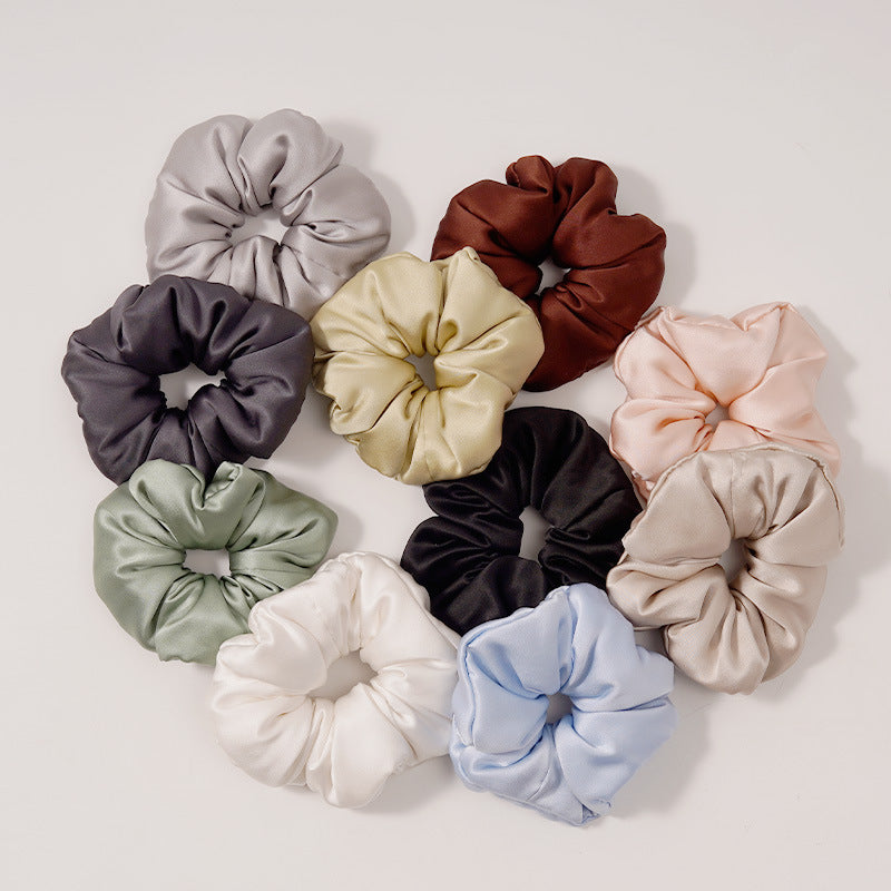Set of satin hair scrunchies in many colors arranged in a circle