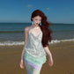 Model in halter sequin dress walking under warm gallery light