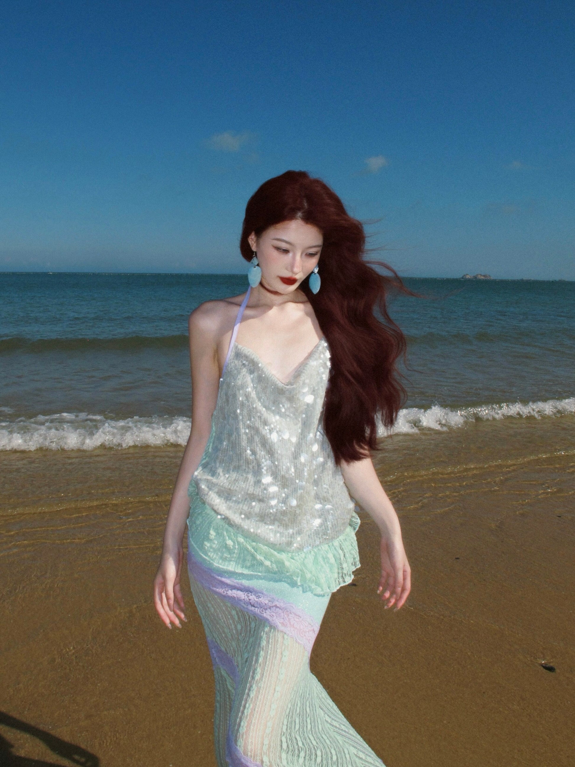 Model in halter sequin dress walking under warm gallery light