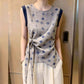 Front view of gray sleeveless blouse worn over cream wide-leg trousers