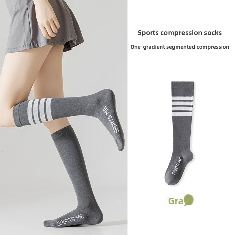 Grey long tube sports compression socks with white stripes worn on the leg and shown flat