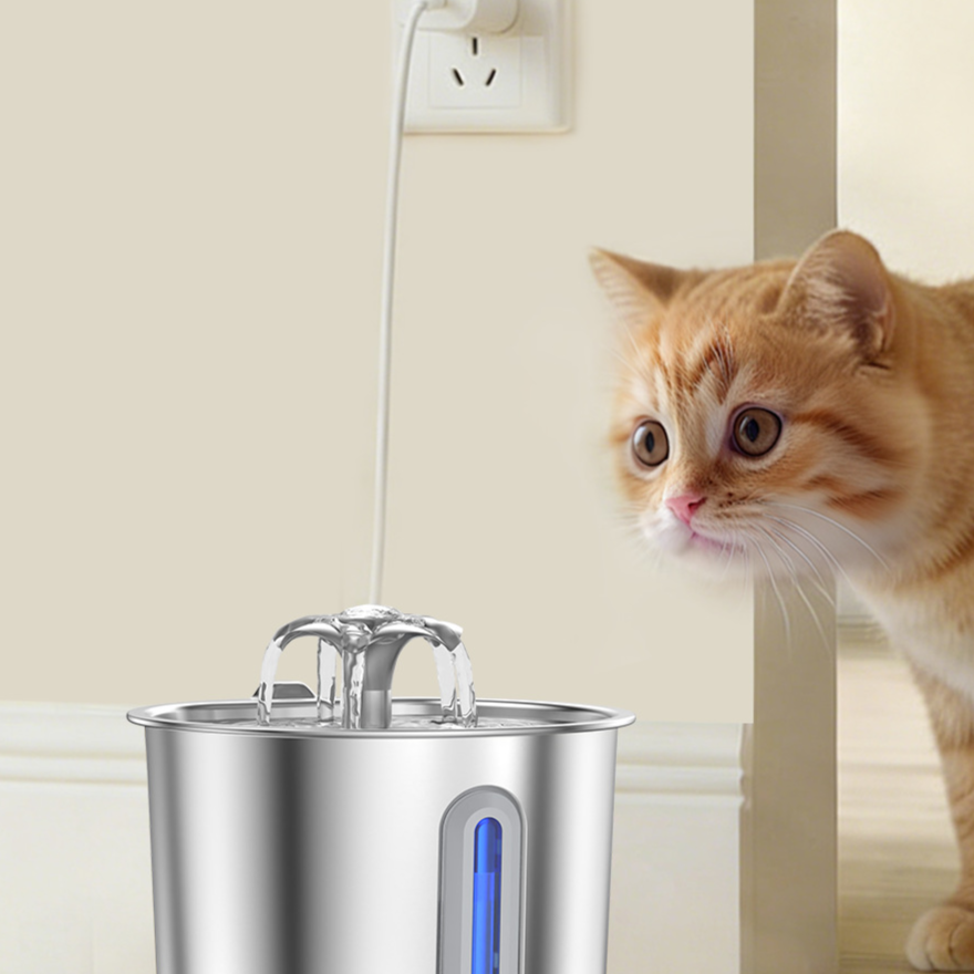 Ginger cat beside a stainless steel pet water fountain plugged into a wall socket by a doorway