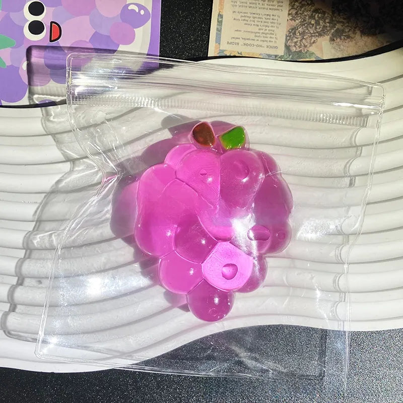 Side view of the crystal grape squishy showing molded grapes and clear translucent gel skin
