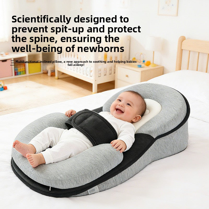 Smiling baby on a grey wedge lounger pillow with a black panel and strap, with a text overlay in the corner