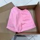 Pink high waist linen shorts laid flat showing loose wide-leg cut and hem