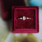 Teardrop cabochon ring with twin opals displayed in a red velvet box