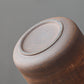 Ceramic storage jar held in hand to show its counter size and scale