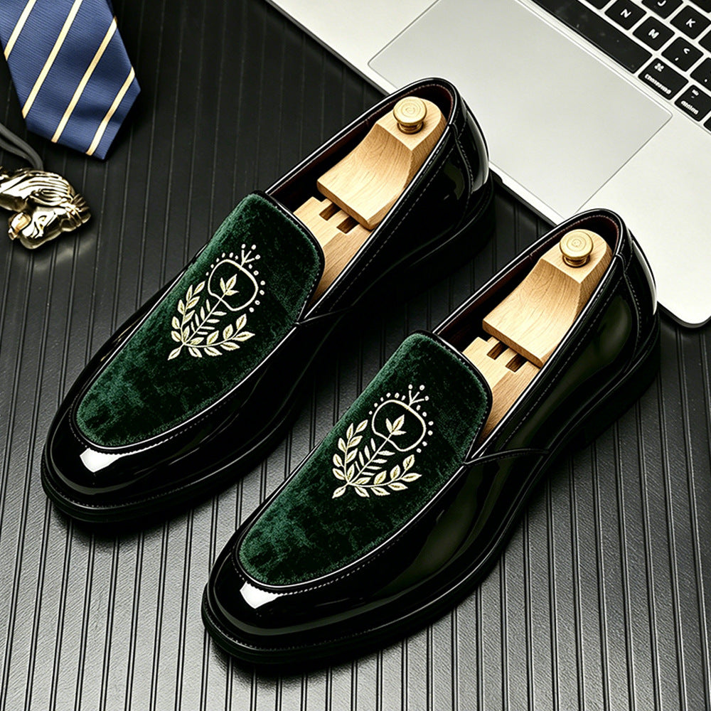 Glossy black loafers with a dark green velvet vamp and an embroidered laurel crest on a desk with a tie, size 46 option