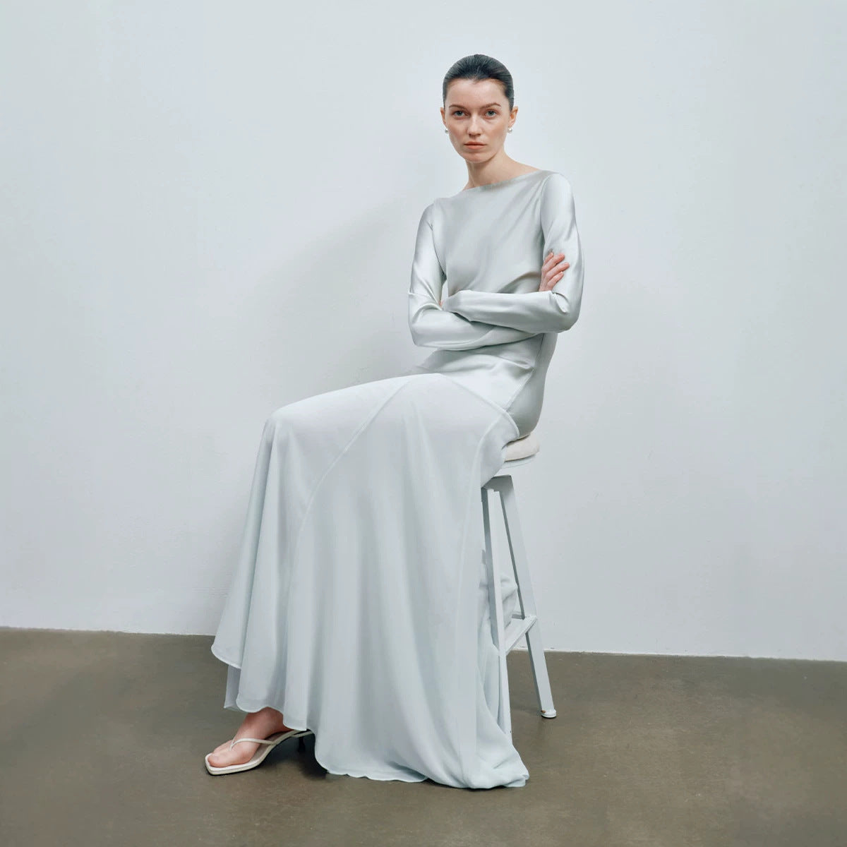 Angled view of the long mint satin gown showing the flared fishtail skirt