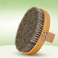 Oval horsehair body brush with a beech wood base and a beige hand strap on a green gradient background
