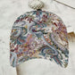 Colourful floral print cap laid flat to reveal the curved shading peak