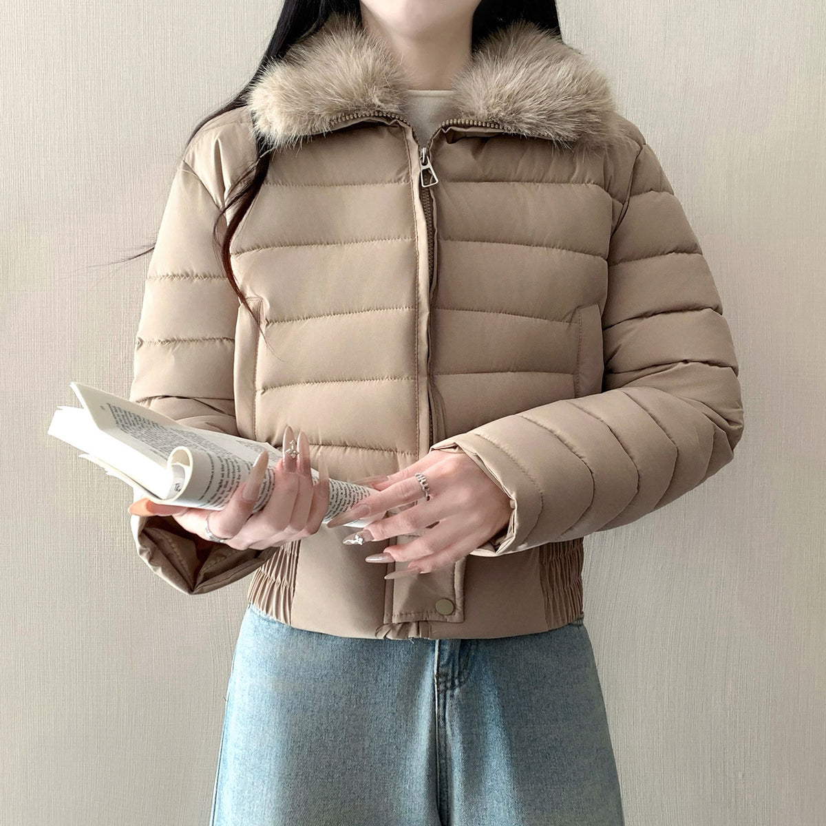 Coffee cropped padded puffer jacket with a faux fur collar worn zipped on a model