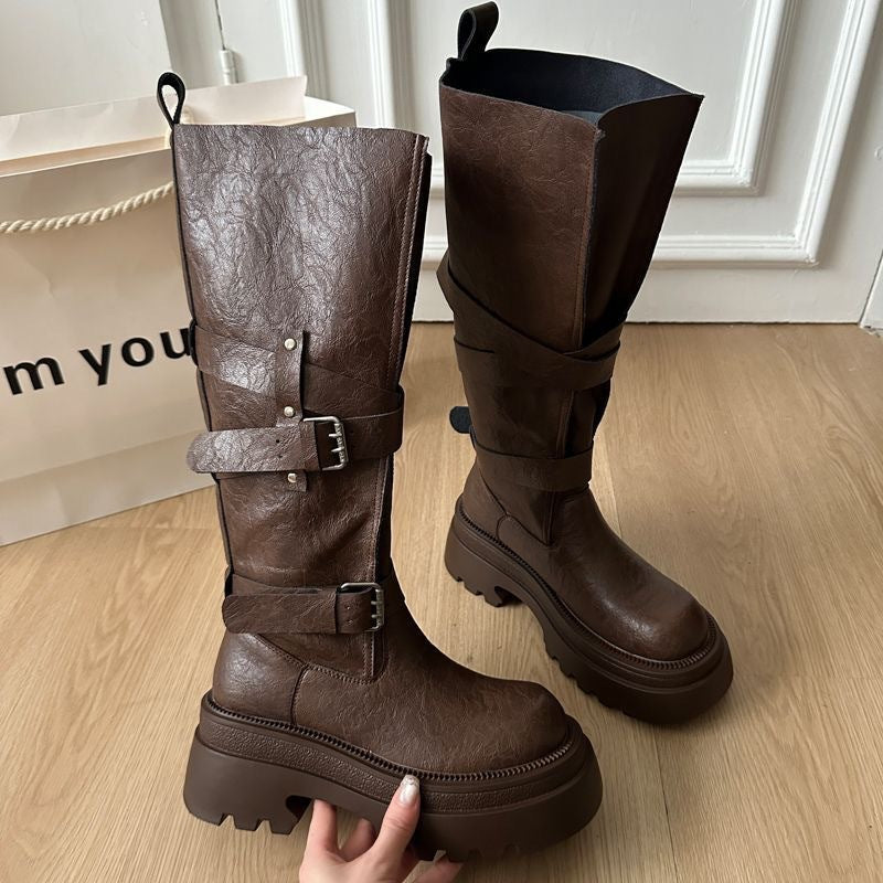 Platform mid calf boots with twin ankle buckle straps shown on a wood floor